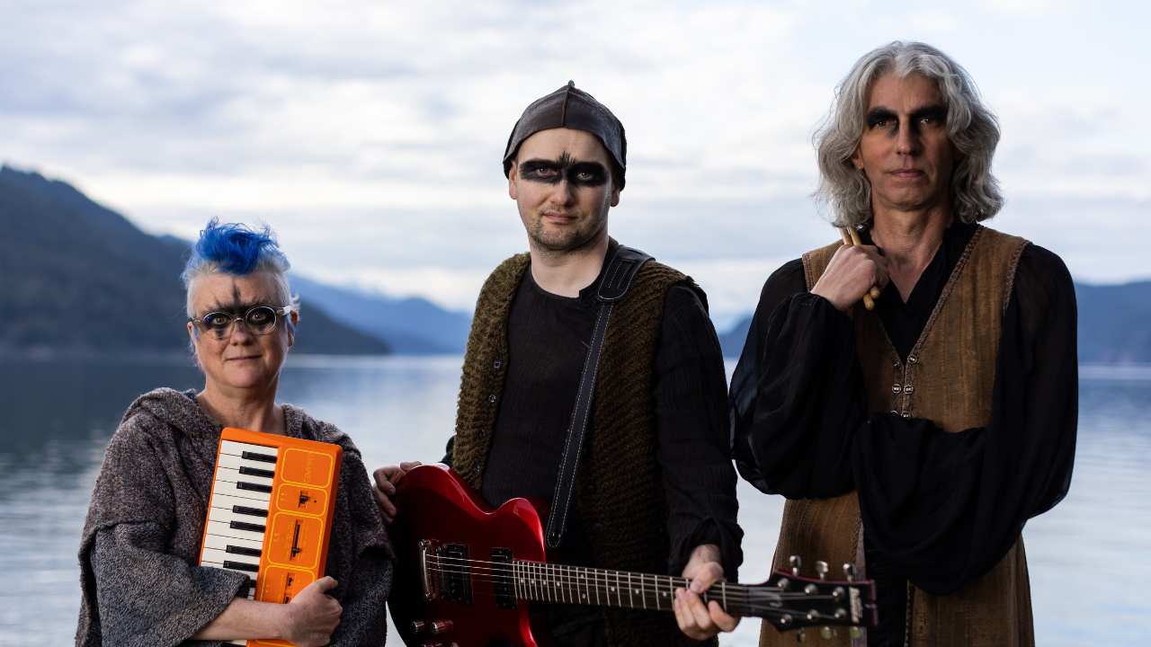 three people with eye makeup & musical instruments